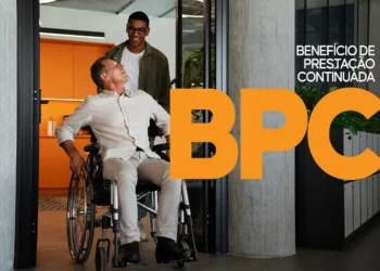 Homem em cadeira de rodas, sorrindo e recebendo ajuda para entrar em um ambiente, destacando o BPC (Benefício de Prestação Continuada) para pessoas com deficiência.