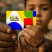 Mãos de adulto e criança segurando cartão colorido do Programa Bolsa Família
