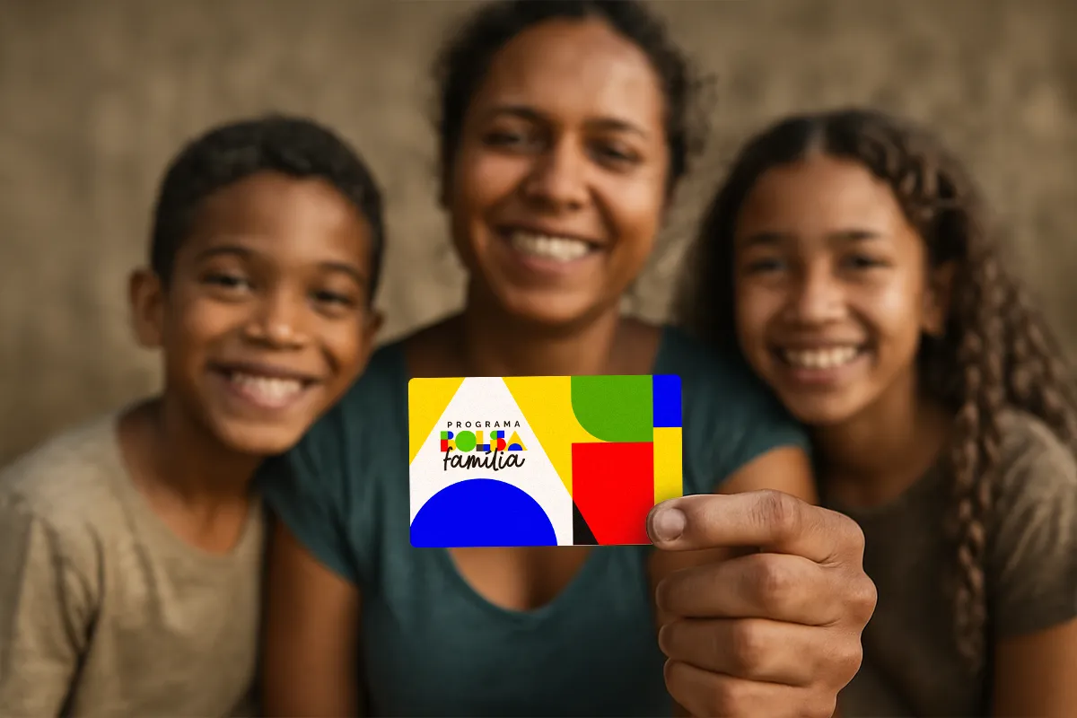 Mulher e duas crianças sorrindo enquanto seguram cartão do Programa Bolsa Família colorido