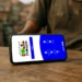 Tela de celular exibindo site do Programa Bolsa Família com botão de acesso e informações