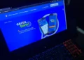Interface do CAIXA TEM exibida em notebook mostrando a tela inicial do aplicativo.