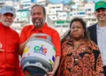 Quatro pessoas, entre elas homens e uma mulher, seguram botijão do programa Gás do Povo com expressão alegre