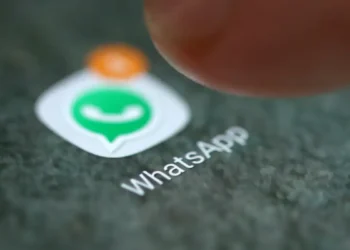 Close do dedo sobre o ícone do aplicativo WhatsApp com notificação de mensagem