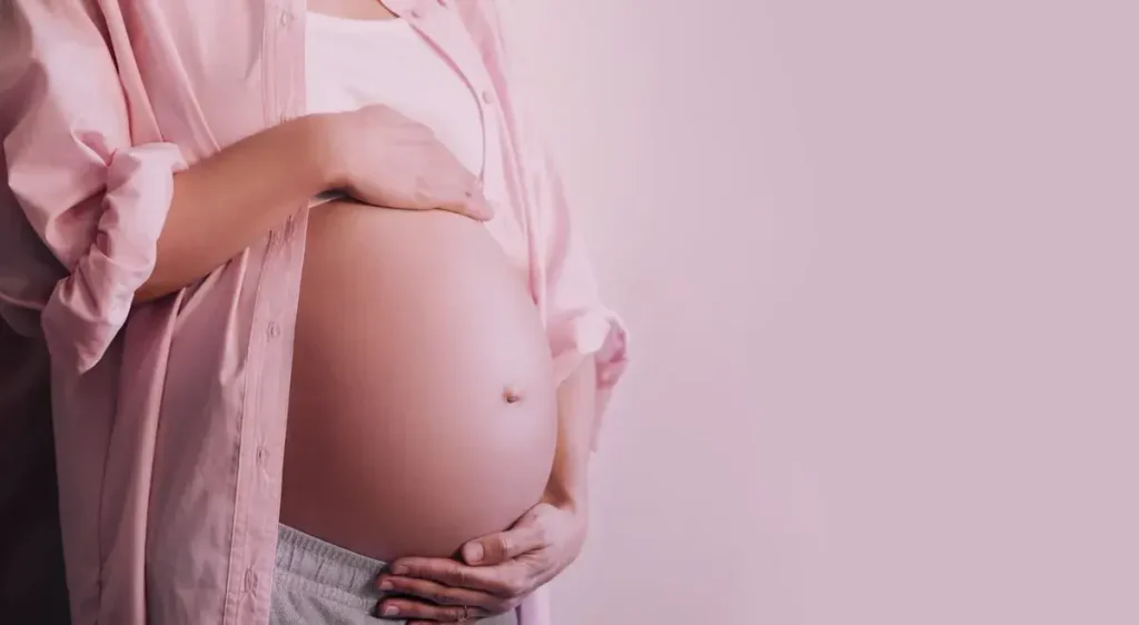 Imagem de uma mulher grávida segurando a barriga, ilustrando a importância do pré-natal obrigatório como condicionalidade para a manutenção do Bolsa Família.