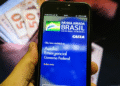 Aplicativo da Caixa mostra tela do Auxílio Emergencial no celular.