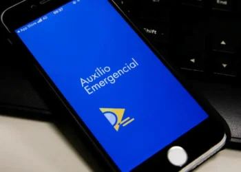 Imagem do aplicativo de Auxílio Emergencial do MDS em um celular, simbolizando a operação de notificação para devolução de valores.