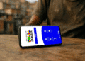 Tela do aplicativo Bolsa Família aberta em um celular sobre uma mesa.