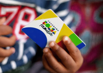 Cartão do programa Bolsa Família sendo segurado por uma pessoa.