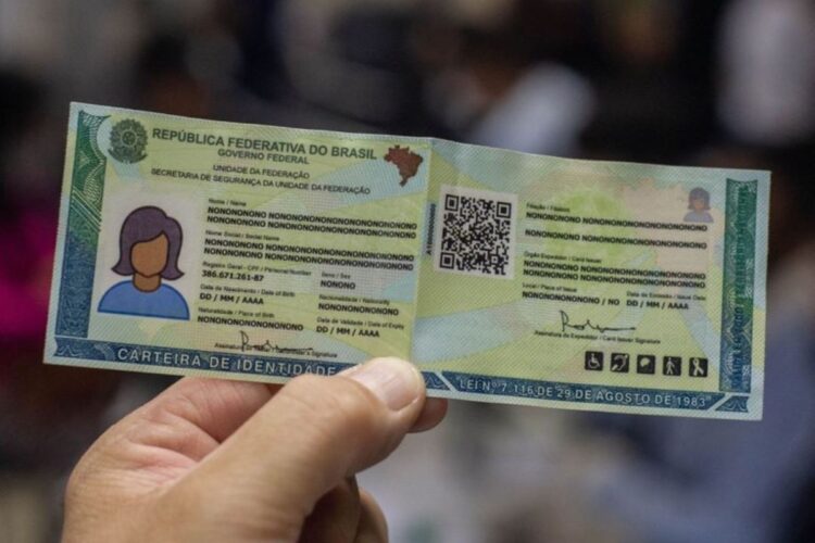 Uma mão segura a Nova Carteira de Identidade Nacional (CIN) verde e amarela com dados genéricos e um QR Code visível. Documento usado para ilustrar o mutirão do SAC para crianças e adolescentes.