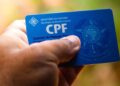 Imagem de um CPF em uma mão, destacando a importância do registro para programas sociais, como o Bolsa Família e o não impedimento do CPF negativado.