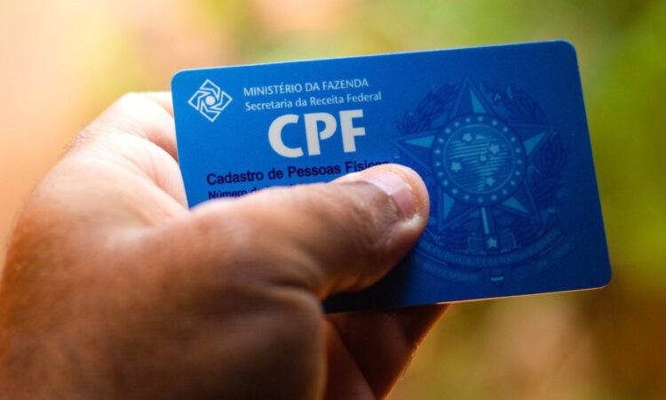 Imagem de um CPF em uma mão, destacando a importância do registro para programas sociais, como o Bolsa Família e o não impedimento do CPF negativado.