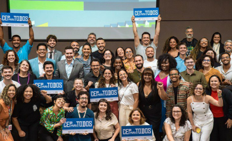 Grupo de pessoas celebra a implementação do CEP em todas as favelas do Brasil.