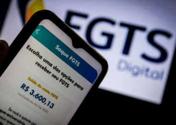 Celular exibindo saldo do FGTS e opção de saque, com logotipo do FGTS Digital ao fundo.