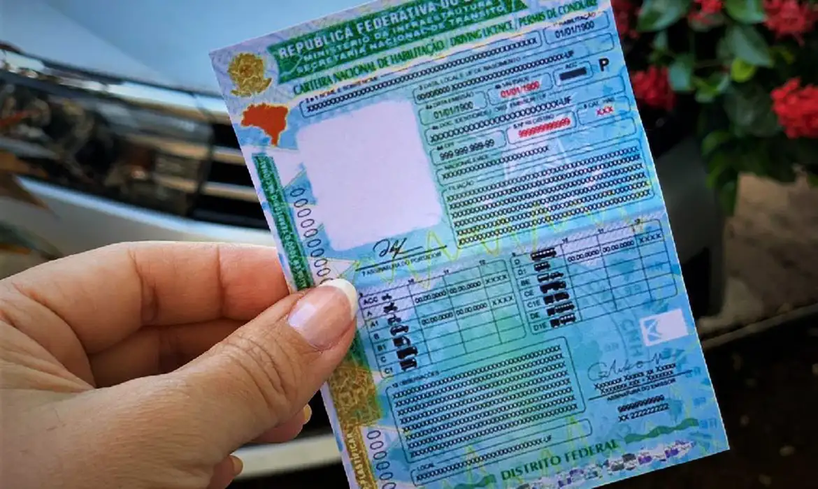 Mão-segurando-a-nova-Carteira-Nacional-de-Habilitação-CNH-representando-a-conquista-do-documento-por-meio-da-CNH-Social