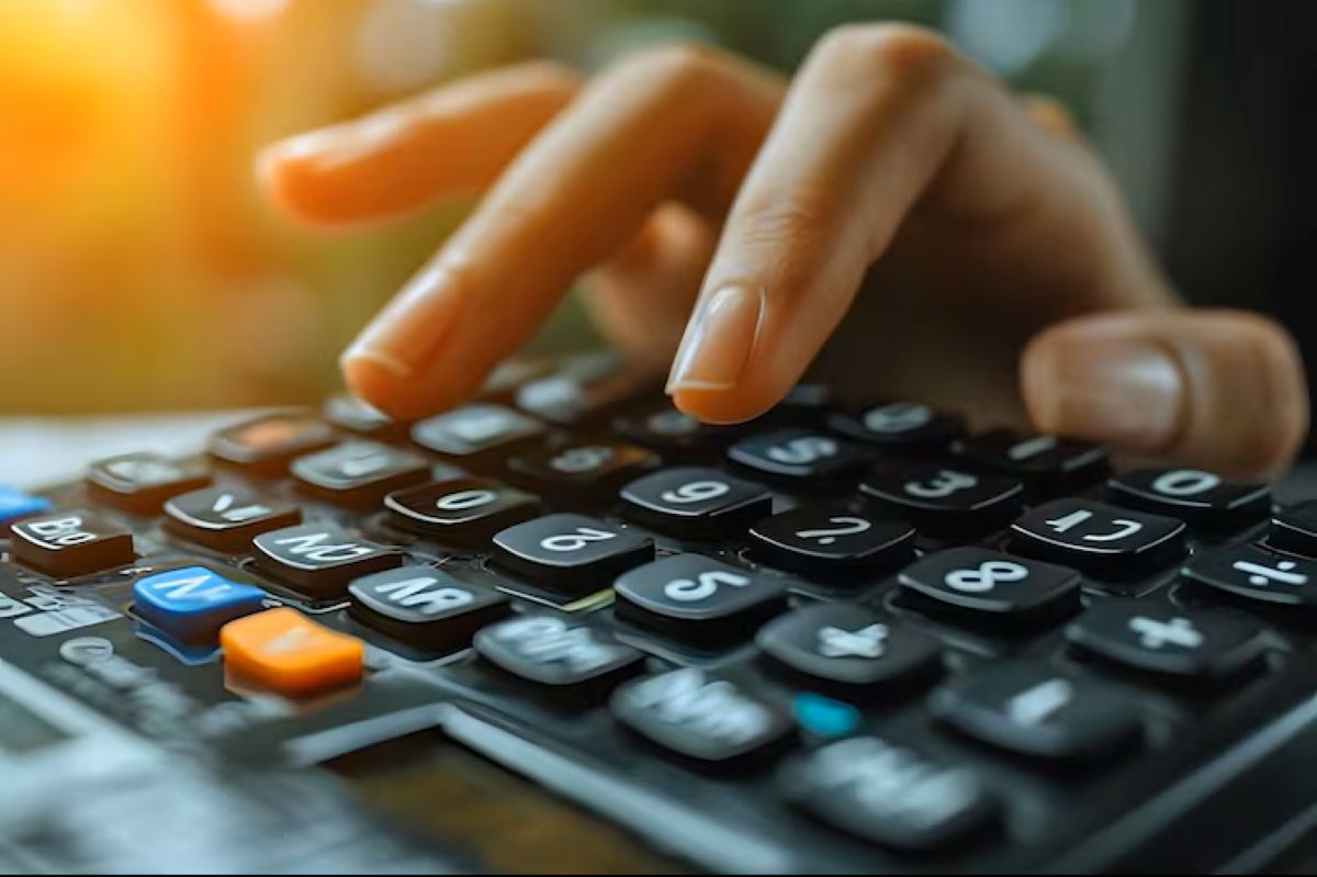 Pessoa utilizando uma calculadora para calcular a renda como MEI para manter o Bolsa Família