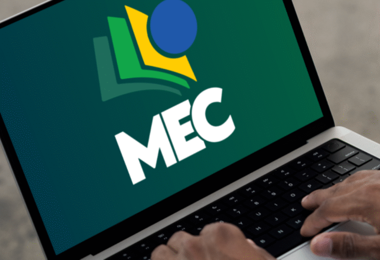 Pessoa usando notebook com logo do MEC na tela, simbolizando anúncio oficial do ministério.