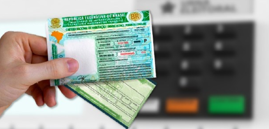 Mão segurando CNH e o e-Título em frente a terminal de autoatendimento.