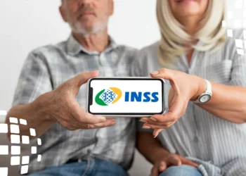Casal de idosos exibindo o logo do INSS em um smartphone, simbolizando a antecipação de benefícios para vítimas de tornado.