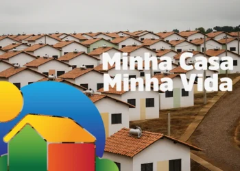 Conjunto habitacional com diversas casas idênticas, telhados de cerâmica e aquecedores solares, com o logotipo 'Minha Casa Minha Vida', simbolizando moradia popular e programas de habitação.