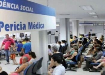 Interior de uma agência da Previdência Social, com várias pessoas aguardando para realizar a perícia médica durante o mutirão.