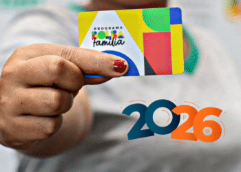 Pessoa segurando um cartão do Programa Bolsa Família com o número “2026” em destaque.