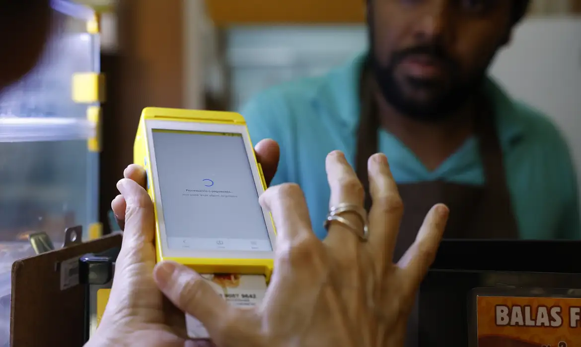 Cartão Alimentação Imagem de um comerciante passando um cartão