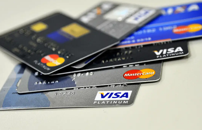 Cartões de crédito Visa e Mastercard sobrepostos com chips e logotipos visíveis.