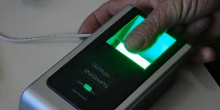 Mulher posicionando dedo em sensor biométrico de impressão digital para autenticação