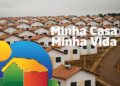 Conjunto habitacional do programa Minha Casa Minha Vida com casas geminadas de telhado laranja e caixas d'água, beneficiando faixas de renda baixa com limite de imóvel ampliado pelo governo.