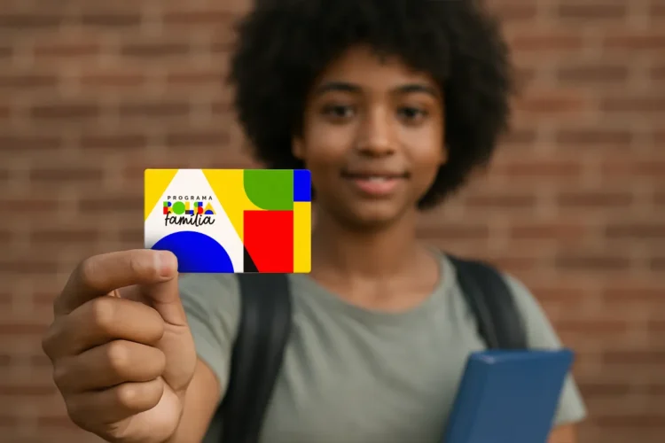 Jovem segurando cartão colorido do Programa Bolsa Família com foco no cartão.