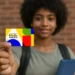 Jovem segurando cartão colorido do Programa Bolsa Família com foco no cartão.