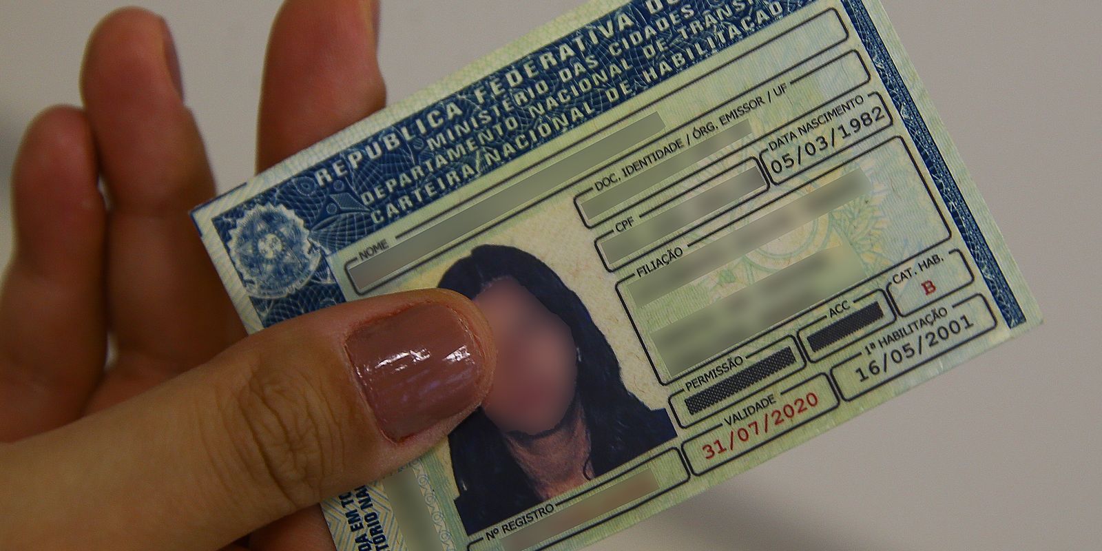 Fim da Autoescola Obrigatória? As 7 Principais Mudanças na CNH Que Vão Economizar Seu Tempo e Dinheiro em 2025 Cédula da Carteira Nacional de Habilitação (CNH) sendo exibida na tela de um celular, simbolizando as novas regras de obtenção e a digitalização do processo, incluindo o fim da obrigatoriedade das aulas de autoescola.