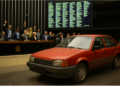 Seu carro tem mais de 20 anos? Câmara aprova isenção de IPVA; entenda o que muda 16 Carro vermelho antigo estacionado em frente a parlamentares votando em plenário
