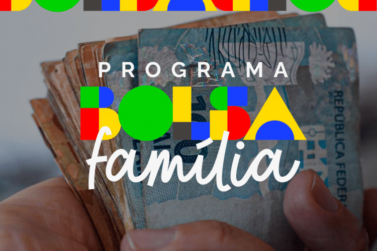 Mão segurando notas de real com arte gráfica do programa Bolsa Família ao fundo.