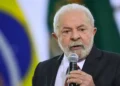 Presidente Lula diz que salário mínimo de R$ 1.621 é baixo e quer novo aumento 2 Lula discursando em evento com bandeira do Brasil ao fundo.