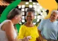 Aposentadoria em 2026: o que muda com as regras de transição da reforma da previdência 12 Pessoas sorrindo em um encontro social com fundo colorido, destacando a alegria e a interação entre beneficiários do INSS.