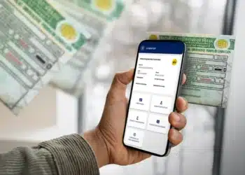 CNH automática para bons condutores: veja se você está na lista de beneficiados 6 Pessoa acessando renovação automática da CNH no celular ao lado da CNH física.