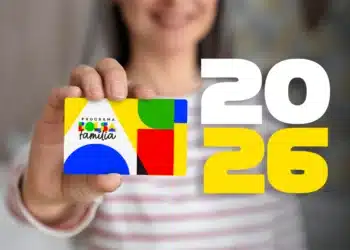 Carnaval pode confundir pagamento do Bolsa Família — entenda para não ser pego de surpresa 6 Pessoa segurando cartão colorido do Bolsa Família com números grandes de 2026 ao fundo.