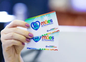 Mães com filhos de até 6 anos recebem R$ 300 nesta sexta (06); confira os critérios 5 Mão feminina com unhas pintadas segura dois cartões do programa Mães de Pernambuco em destaque.